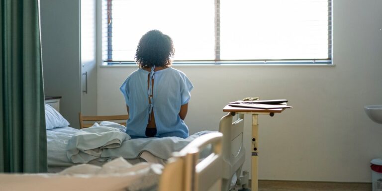 Woman Sitting On Hospital Bed.jpg