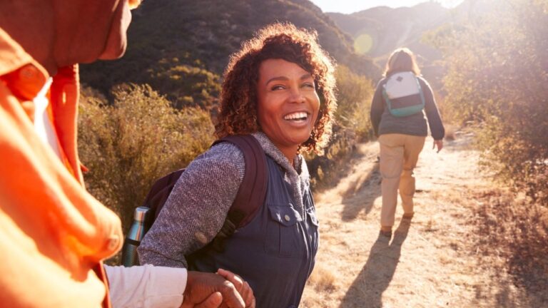 Woman Helping Man On A Hike.jpg