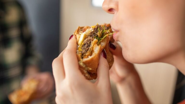 231121172011 Woman Eating Hamburger Stock Image Restricted.jpg