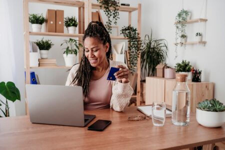 Woman At Home On Laptop And Holding Credit Card Westend61.jpg