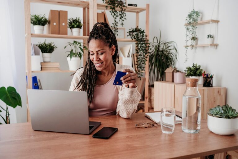 Woman At Home On Laptop And Holding Credit Card Westend61.jpg